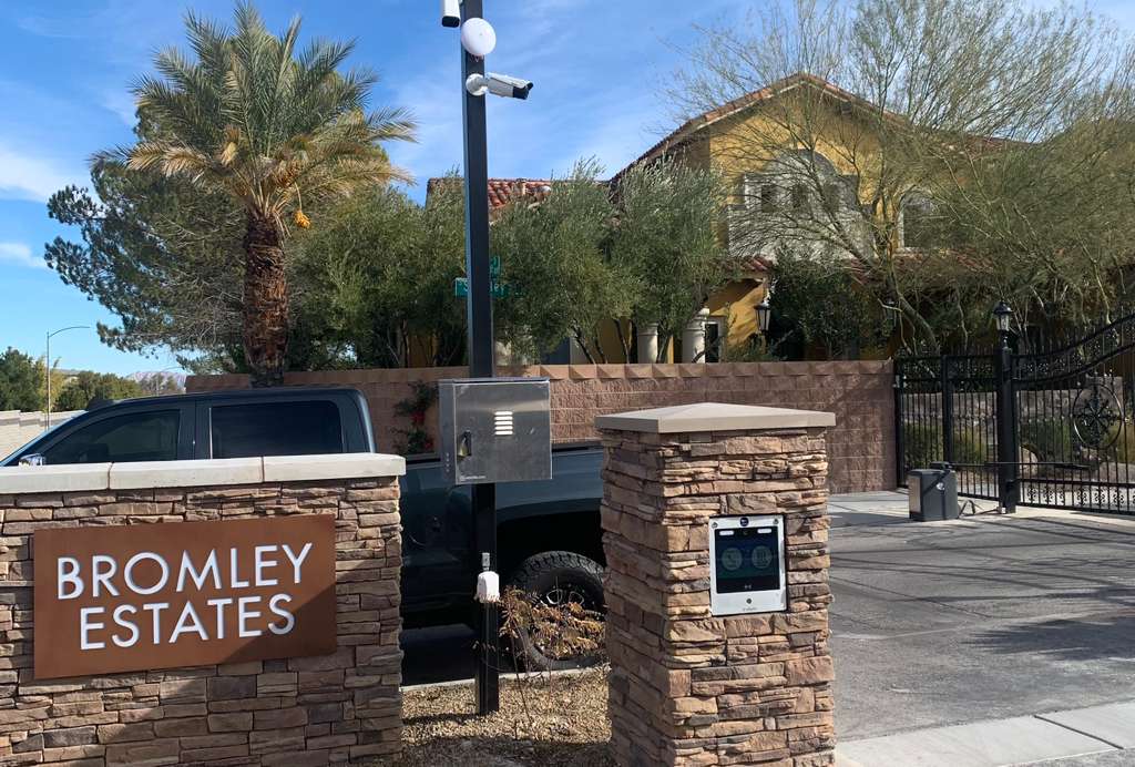 Gated community entrance with access control keypad, card reader and security camera pole in Las Vegas